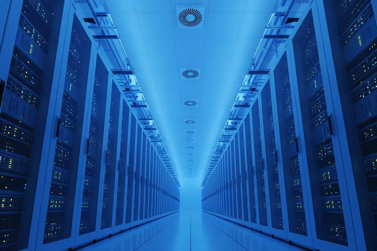 Low-angle view of massive, neatly organized server racks in a modern data center with blue ambient lighting.
