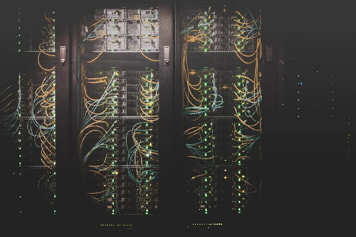 Rows of server racks in a data center with cooling pipes