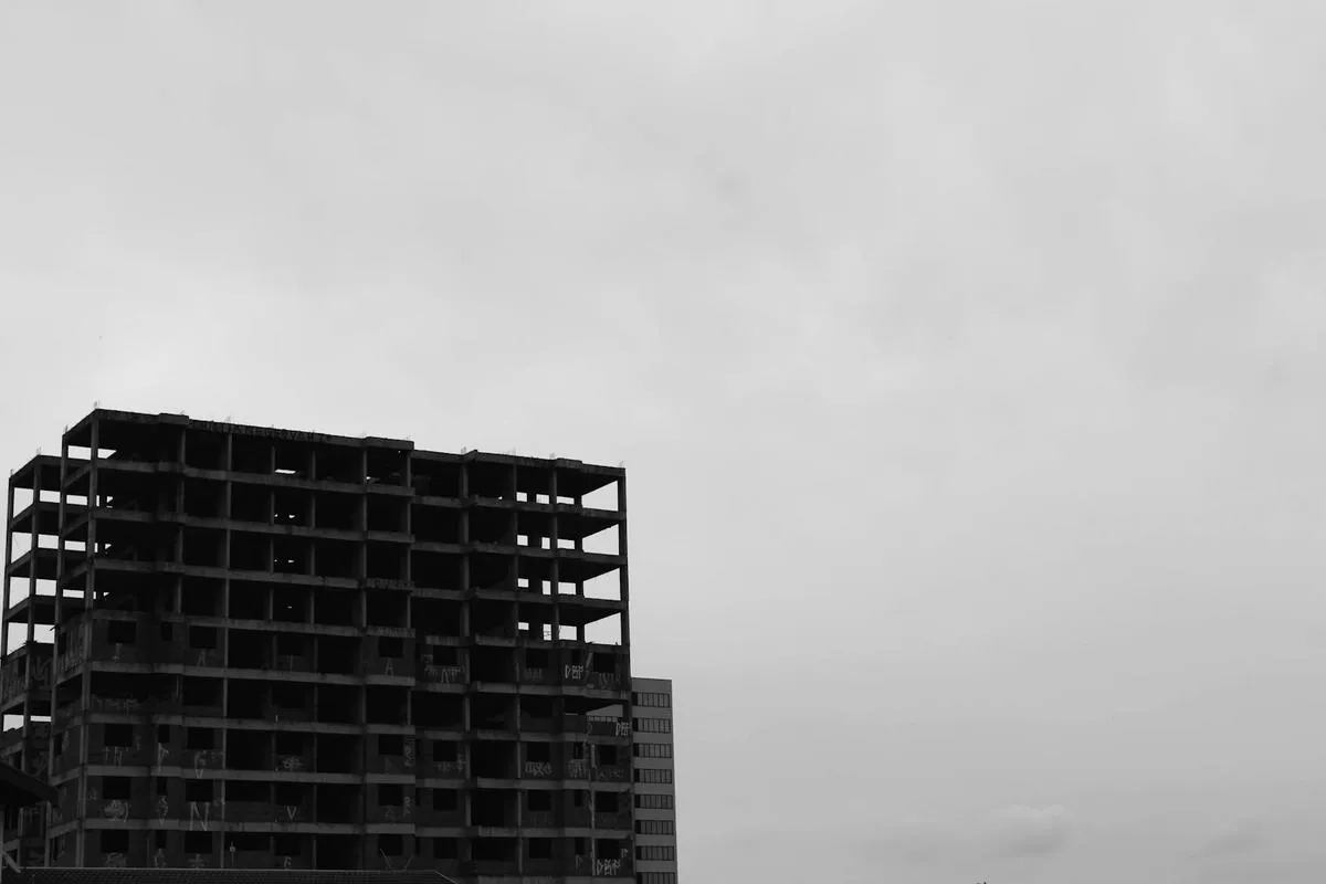 Abandoned condo building with overgrown vegetation
