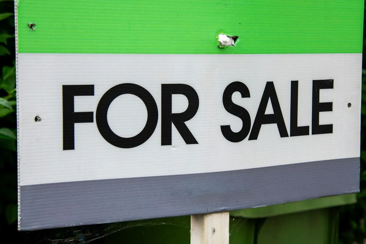 A condo building in a city with a for sale sign
