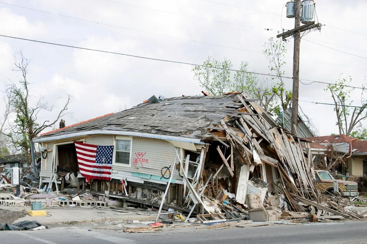 A damaged condo building after a hurricane with debris and cloudy sky.